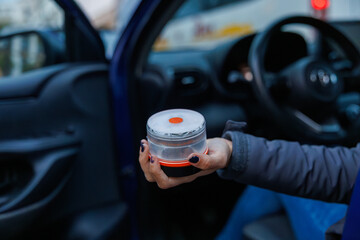 Hand placing a v16 emergency beacon light on a car roof, signaling roadside safety