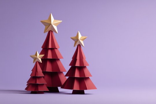 Three dimensional geometric paper sculptures representing evergreen trees topped with gold stars stand against a pale purple background