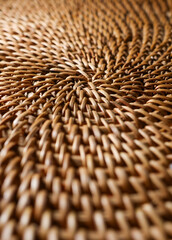 Close up of natural wicker weave creating a spiral pattern, showing craft and intricate texture