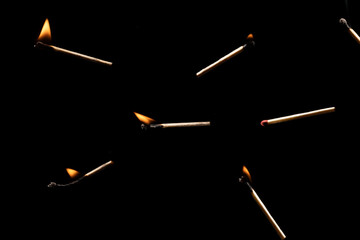 Lit falling match on a black background.