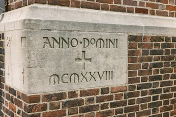 Historic stone inscription on a brick building from the year 1928 in a city setting