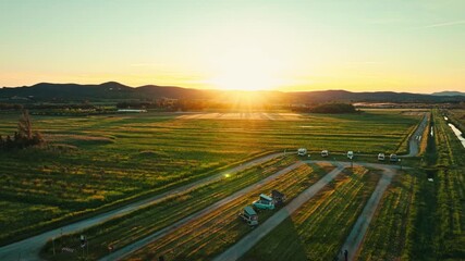 van parked in open fields next to the sea at sunrise, stunning aerial footage, road trip and van life good vibes