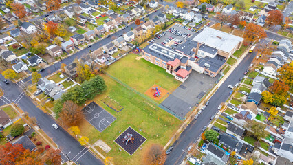 Aerial view of Rahway NJ near East Milton showing homes, winding streets, waterways, the Rahway River and nearby roads like Route 1 and Route 27 under an overcast sky. Scenic suburban landscape.