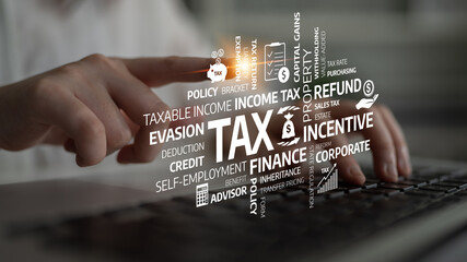 A professional setting displaying a finger pointing at various tax-related terms over a laptop keyboard. This image represents the finance and accounting industry vividly. Tessel