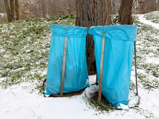 outdoor garbage bins covered with blue plastik bag