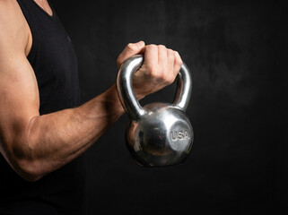 Man Holding Heavy Kettlebell in Dark Gym