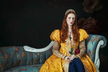 A red-haired woman wearing a gold historical-style robe with puffy sleeves. She's holding a red rose