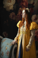 A red-haired woman wearing a historically styled gold gown with puffy sleeves