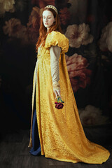 A red-haired woman wearing a historically styled gold gown with puffy sleeves