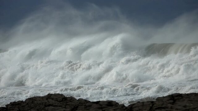 Big waves, wind sea spray, blue sky