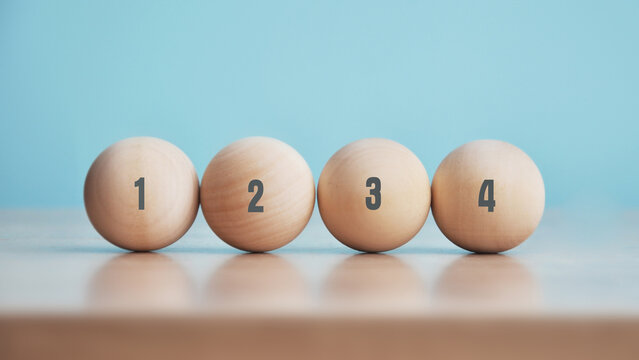 Numbered wooden balls 1,2,3,4 on a blue background – The concept of sequence and order
