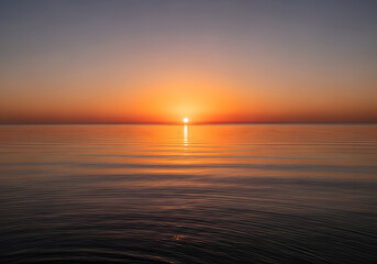 Fototapeta premium A serene seascape showcasing a beautiful sunset over the calm ocean
