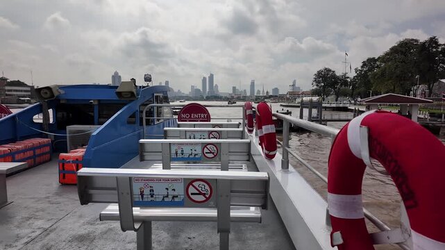 BANGKOK, THAILAND - 1ST OCTOBER 2024: POV clip looking towards front of tour boat on Chao Phraya River in Bangkok with skyline in background