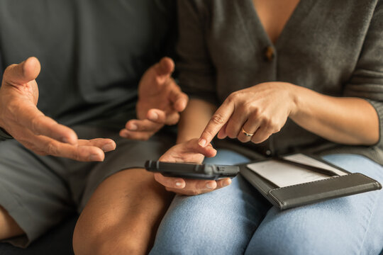 Couple discussing something on a smartphone during a disagreement