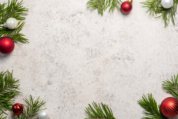 Festive holiday decorations featuring red and white ornaments with evergreen branches on a light background