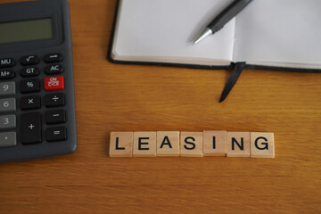 leasing. financial concepts. wooden letters with office supplies in the background