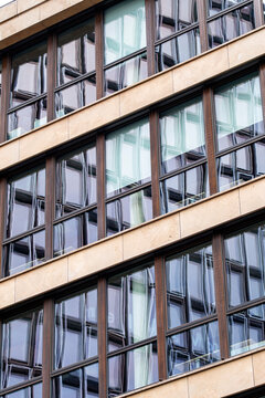 Architecture facade reflection forming a pattern of geometry in a modern glass structure with urban design elements expressed through contemporary style aesthetics