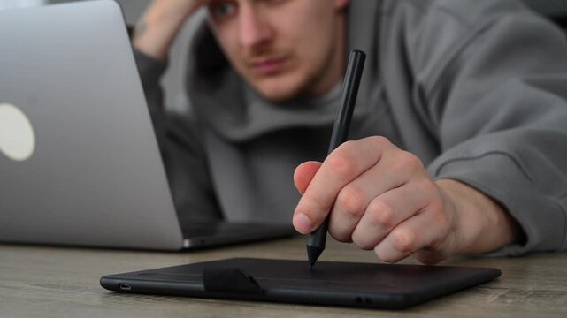 A man working with digital materials.
Using a graphic tablet and stylus.
A man in a fois draws on a graphics tablet.
Photo editing and office work