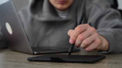 A graphic designer sits at a desk and draws with a stylus.
Photo retouching and digital work with art materials.
A freelancer performs editing work.
Work, digital, hand, stylus, tablet, laptop
