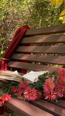 Cozy autumn reading spot with a blanket, a book, and blooming flowers in a serene natural setting