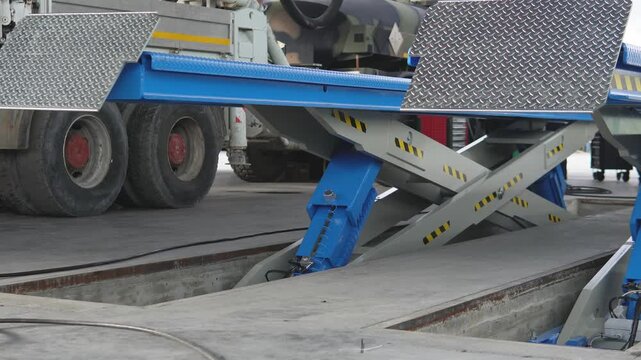 Hydraulic lift in a car service center. Testing a 30,000 kg lifting capacity lift. This lift is ideal for car service centers, professional tool repair shops, and mechanical workshops.