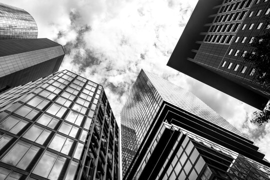 Architectural skyscraper geometry rising across the skyline of Frankfurt Germany, blending modern corporate finance atmosphere with mirrored reflection effects under a bold perspective