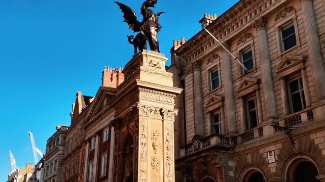 Wide angle shot of a Dragon Boundary Mark, a cast iron statue on a stone plinth marking the boundaries of the City of London, England, UK