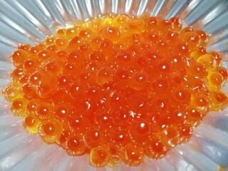 海鮮高級食材 銀紙に盛り付けられた新鮮なオレンジ色のいくらのクローズアップ