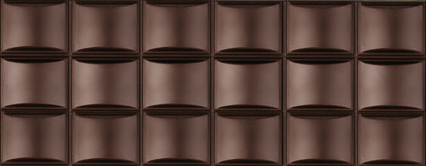 High resolution close-up image of a dark chocolate bar with detailed textured squares, background. The rich brown color, smooth surface
