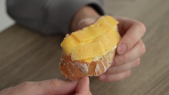 Bread and cheese in a person's hand.
Cheese sandwich.
Healthy snack.
Appetizing sandwich.