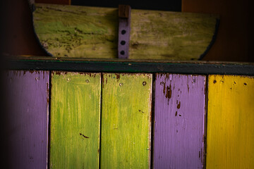 Brightly painted wooden boards showing distressed texture and vivid color in an abstract composition