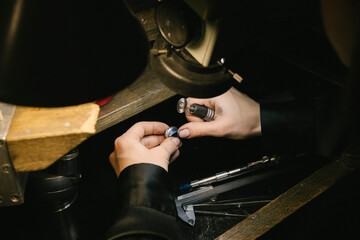 hands jeweler ring repair on bench with magnifying loupe and tools, artisan working on gemstone setting for jewelry making, craft workshop, precision polishing and metal finishing