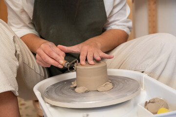 Artisan hands trimming clay on potter's wheel