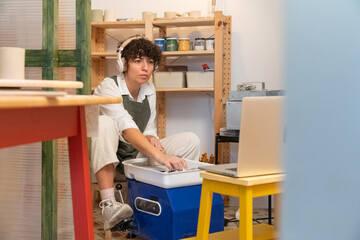 Woman learning pottery online in a creative studio