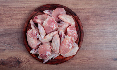 Raw chicken wings, on a wooden board, top view, no people,