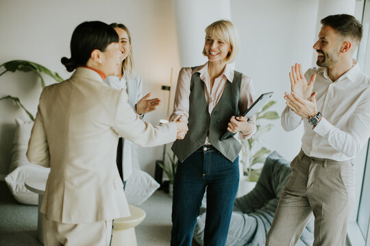Meeting of professionals celebrating a successful collaboration in a bright office space - Powered by Adobe