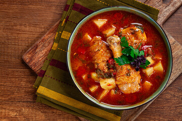 Souzi soup. Georgian dish, meat with oats, tomato sauce and herbs, on a wooden table