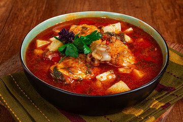 Souzi soup. Georgian dish, meat with oats, tomato sauce and herbs, on a wooden table