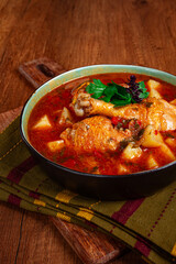 Souzi soup. Georgian dish, meat with oats, tomato sauce and herbs, on a wooden table