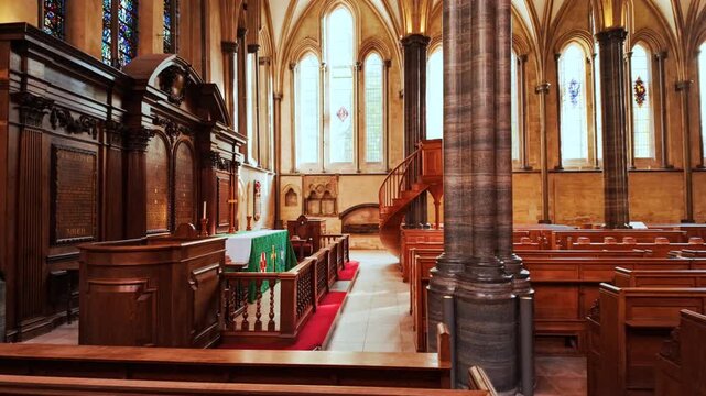 The interior of Temple Church, London, England, UK, with stone arches, columns and a quiet nave lit by soft window light