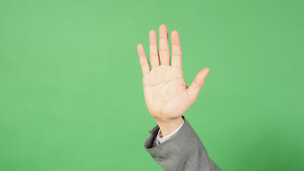 a raised hand showing an open palm gesture on green background.