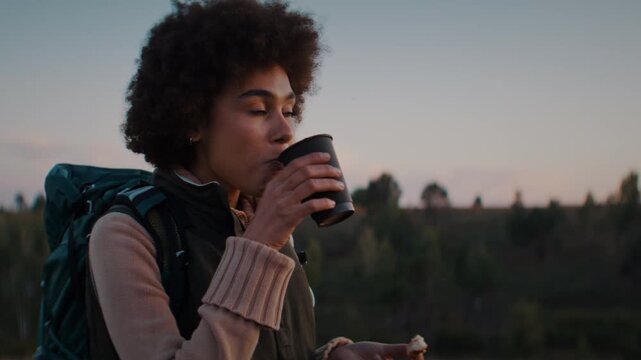 African American woman with kinky hair takes sip of hot tea