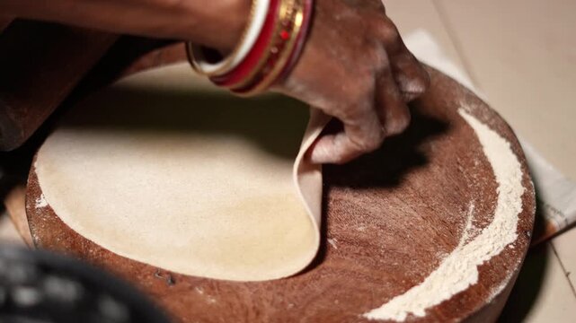 Making Indian flatbread at home. indian woman making chapati roti or indian wheat flatbread in a indian village.