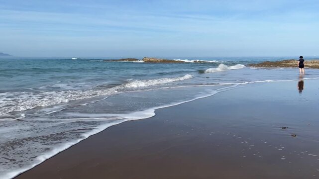 Mujer en la orilla de Itzurun en Zumaia