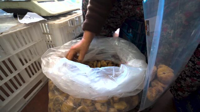 Woman worker packing dried figs in factory