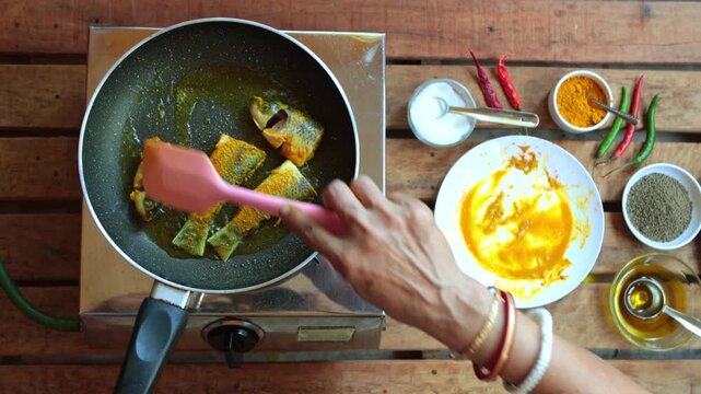 Fish pieces are frying in pan in mustard oil.