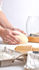 Hands kneading dough on a floured surface, preparing homemade bread.