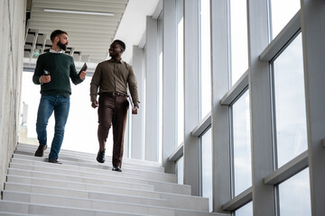 Businessmen discussing future while walking down stairs