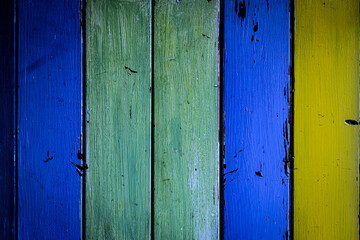 Blue, green and yellow painted wooden planks with distressed, weathered texture and vintage rustic horizontal paneling background, aged