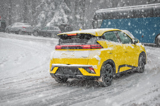 Yellow car driving in heavy winter snowfall